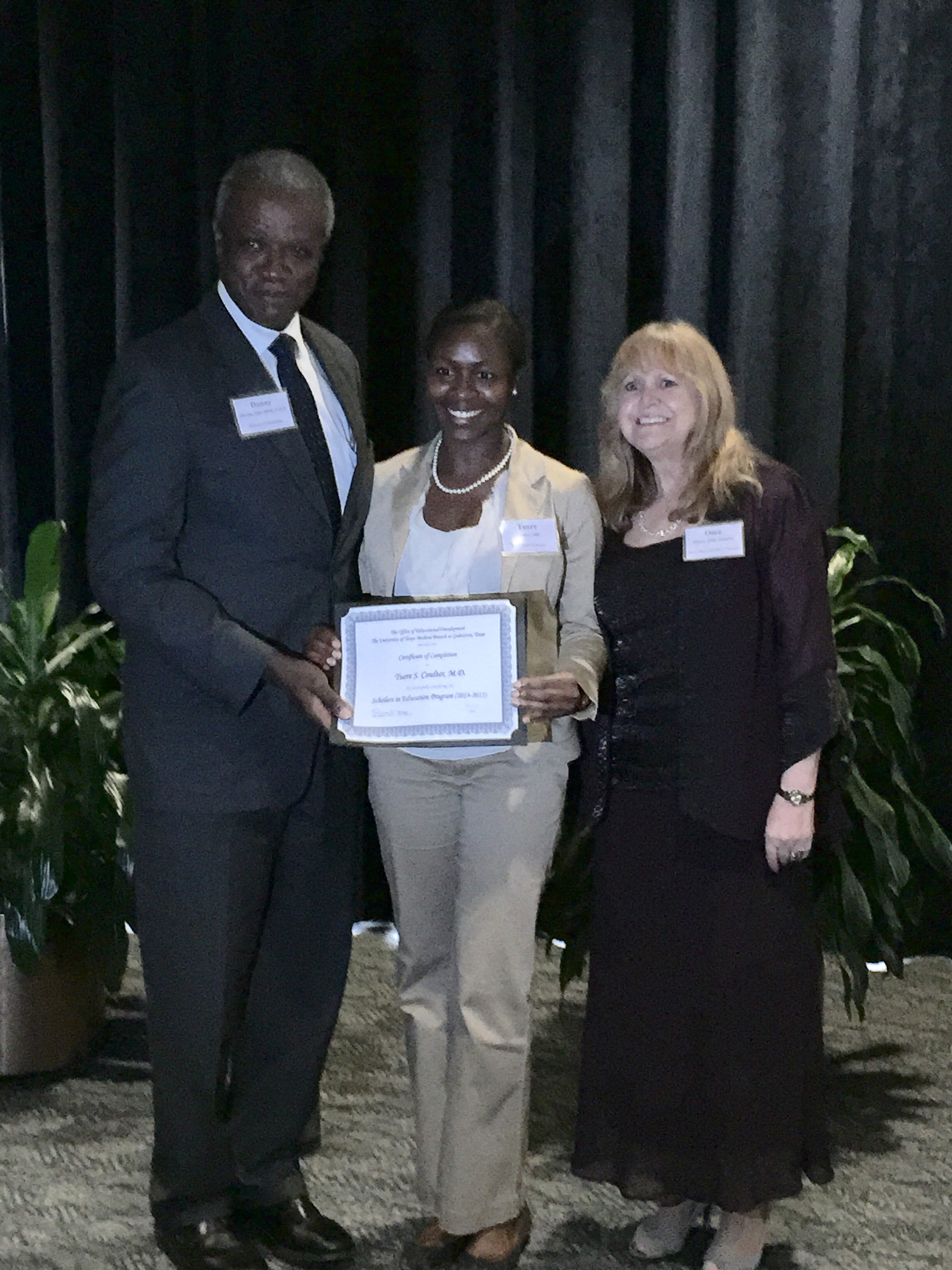 Tuere Coulter, MD (center) receiving her certificate of completion for the UTMB Health Scholars in Education Program