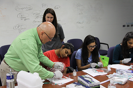 Victor Sierpina, MD demonstrates a technique to students during a hands-on workshop