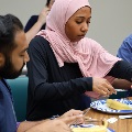 Students working together at a table handling medical training materials and supplies during a small-group clinical skills workshop.